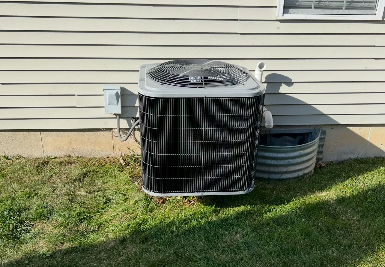 Residential HVAC unit attached to the side of a house installed by PBK HVAC and Mechanical